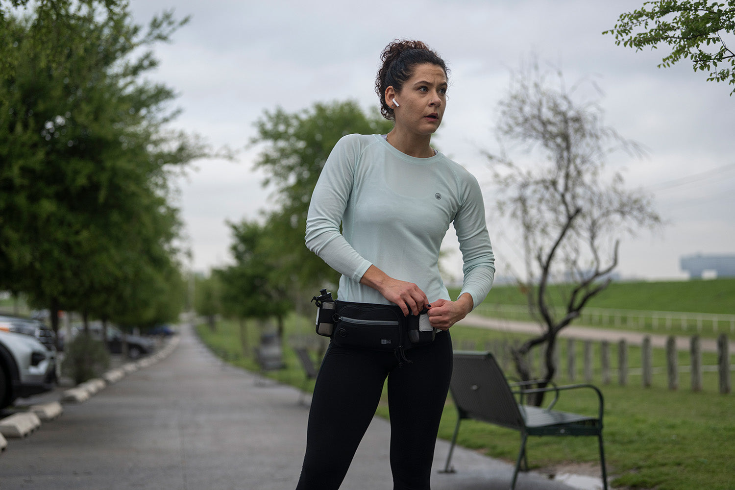 Woman securing strap on Marathon™ Gun Pack