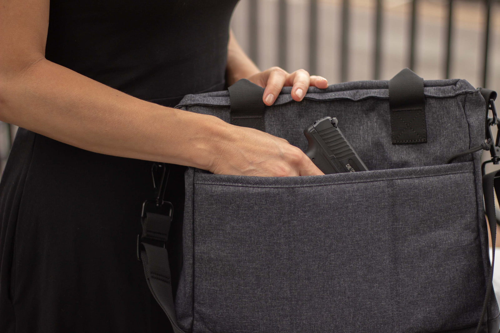 Woman pulling handgun from concealed carry tote purse