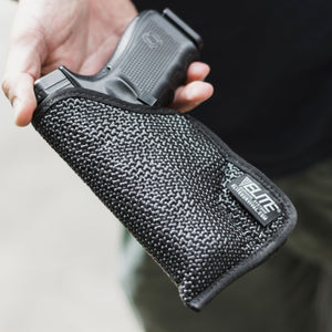 Hand holding a black gun case with a visible brand logo on a neutral background