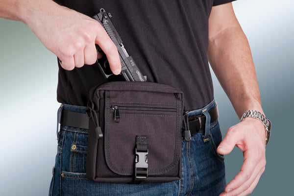 Person wearing a black tactical belt with a pouch and gun holster.
