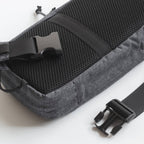 Gray bag with black straps and buckles on a white background