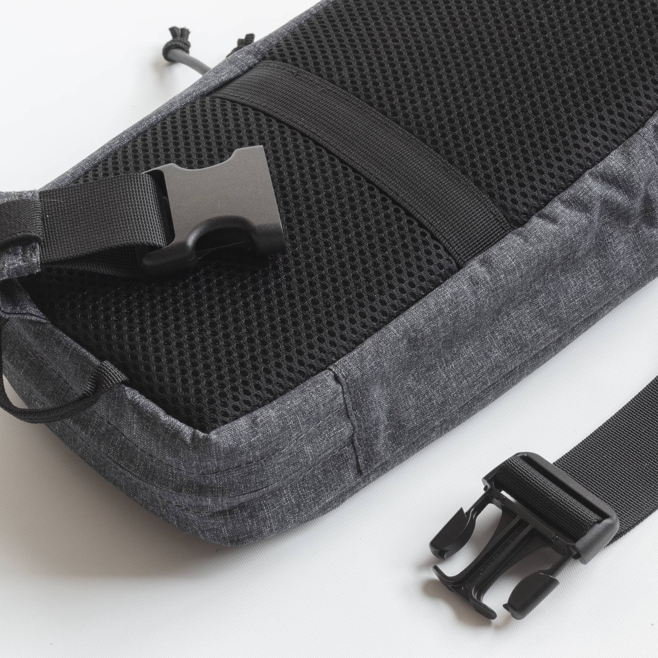Gray bag with black straps and buckles on a white background