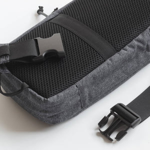 Gray bag with black straps and buckles on a white background