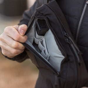 Person opening a black backpack with a blurred background