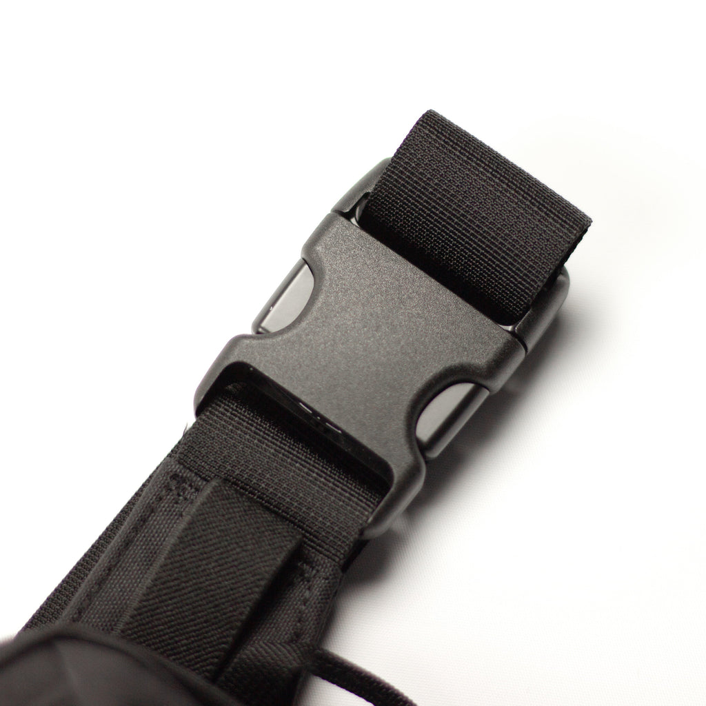 Close-up of a black nylon web strap with a matte black plastic quick-release buckle on a white background.
