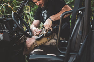 Man working on a vehicle in a natural setting