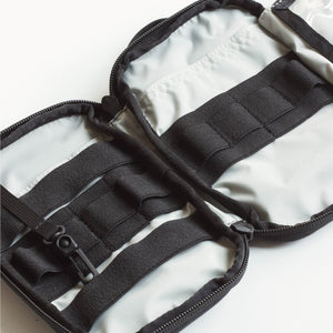 Black zippered pouch with straps on a white background