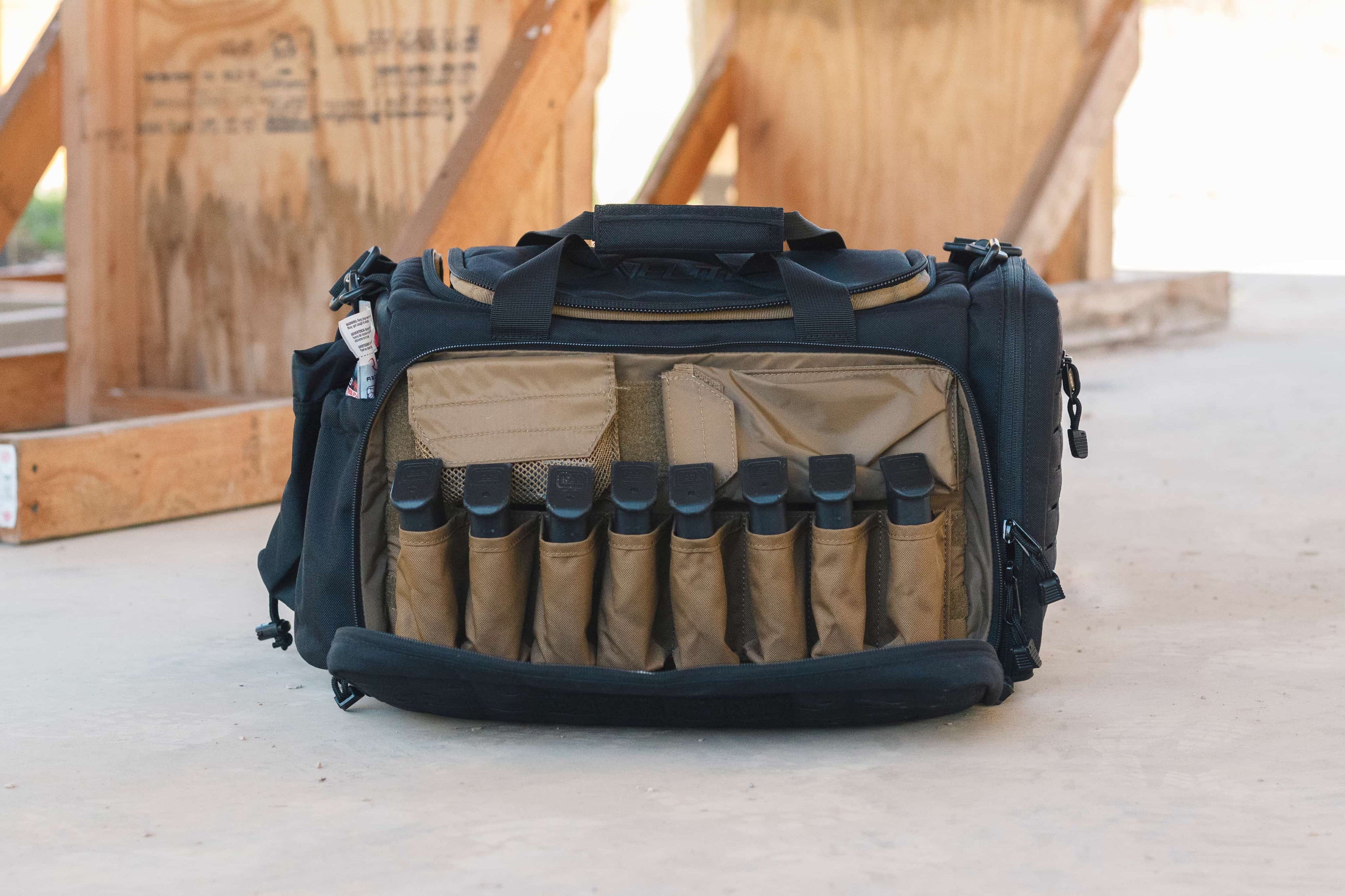 Black and brown tactical bag with ammunition on a concrete surface