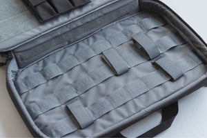 Gray tactical case with multiple straps on a light background