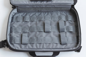 Gray tactical bag with multiple straps on a white background