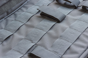 Close-up of a tactical case with multiple straps and patches.