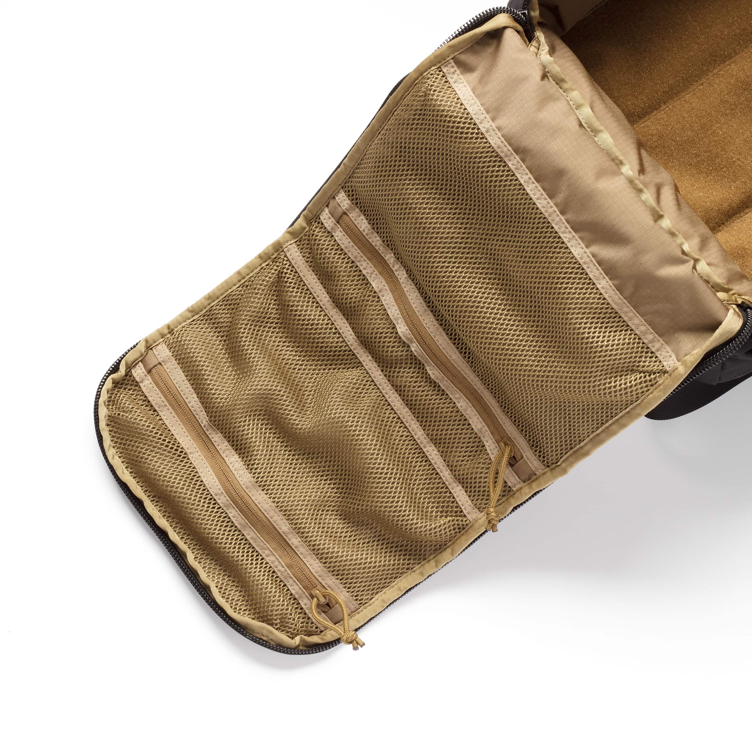 Close-up of the interior of a tan mesh organizer pouch or case, showing multiple zippered compartments and stitched pockets on a white background.