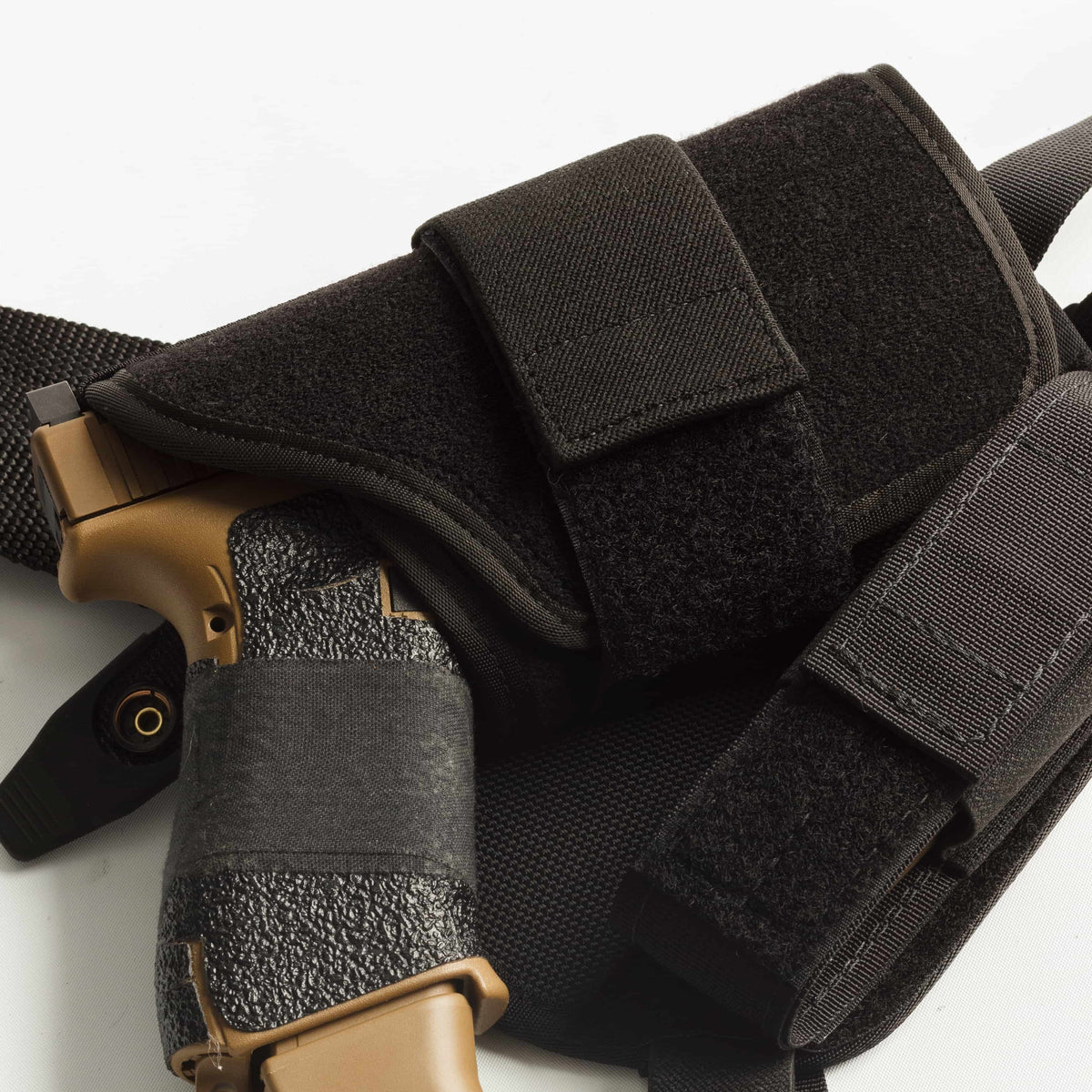 Black tactical holster with a gun on a white background