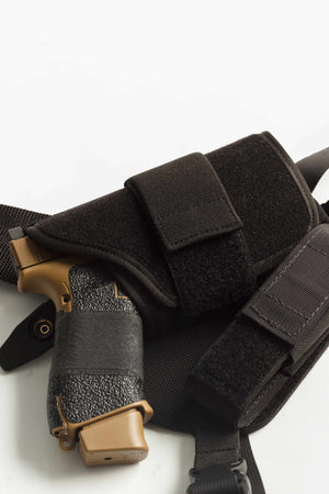 Black tactical holster with a gun on a white background