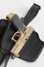 Tan handgun in a black holster on a white background