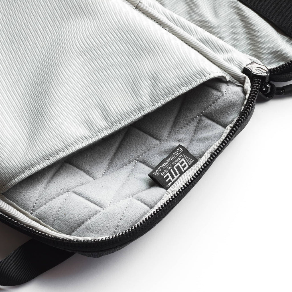Close-up of a light gray fabric bag showing the interior lining, black zipper, and a small black brand tag reading ETE.