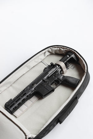 Black rifle inside a white suitcase on a white background