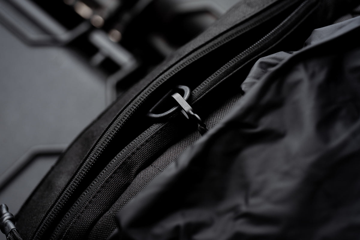 Close-up of a zipper and pull ring on the black Mission Backpack 40L