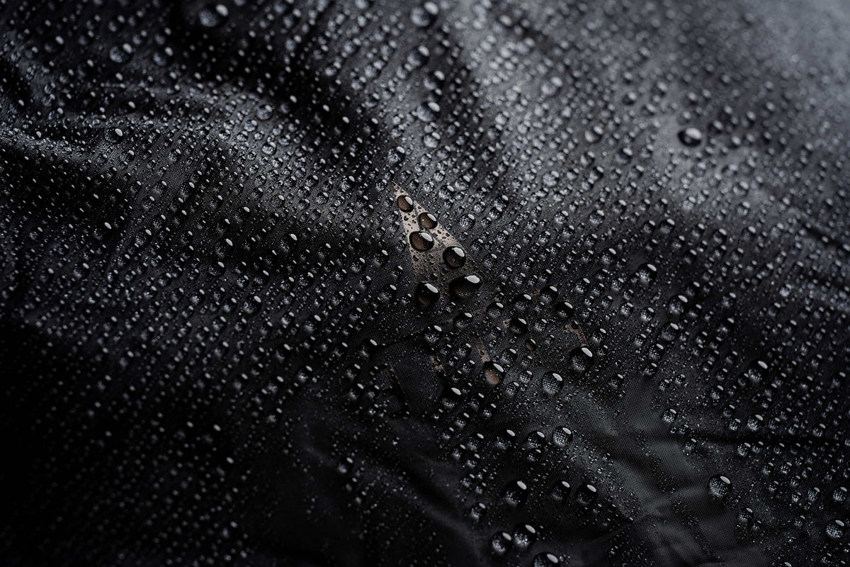 Water beading on the black fabric of the Mission Backpack 40L