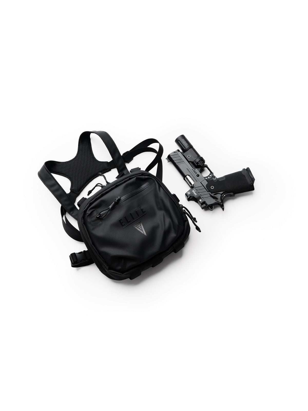 Black TrailGuard Concealed Carry Chest Holster and harness next to a handgun with weapon light, top-down view