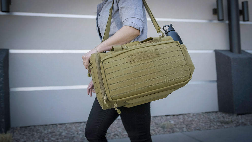 Woman carrying the Loadout Range Bag. The balanced layout of the range bag allows for perfect carry for men and women.
